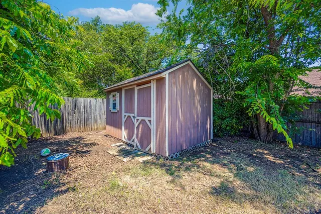 a view of a backyard with potted plants and large tree