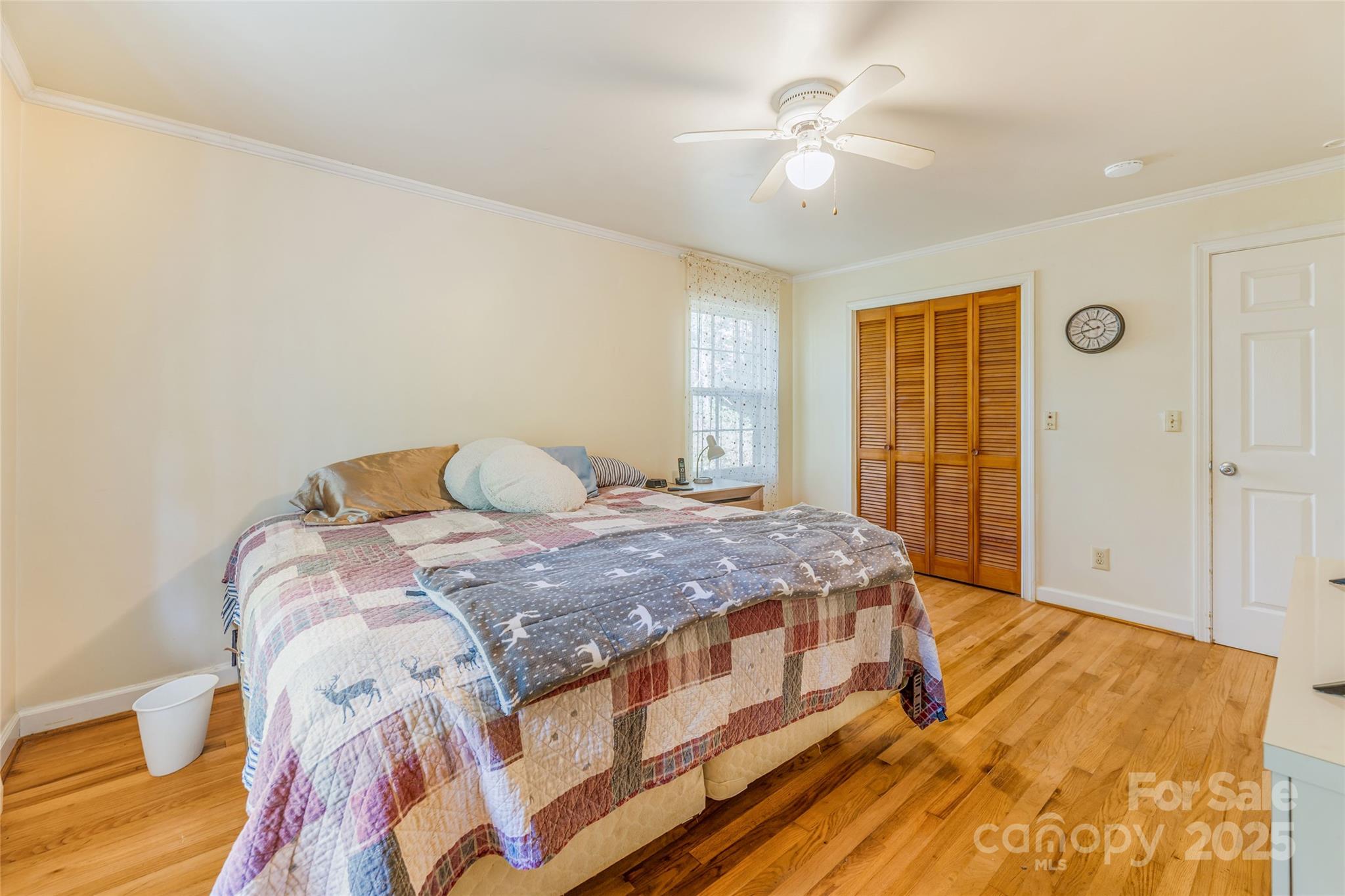 679 Solomon Jones Road Cedar Mountain, NC 28718 - Photo 22 of 47 a bedroom with a large bed and a chandelier