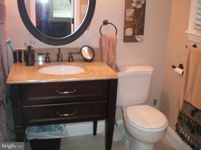 4030 Crescent Road Ellicott City, MD 21042 - Photo 11 of 29 a bathroom with a granite countertop toilet sink and mirror