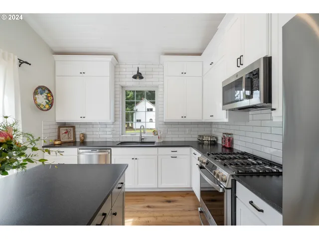 a kitchen with stainless steel appliances granite countertop a sink stove and cabinets