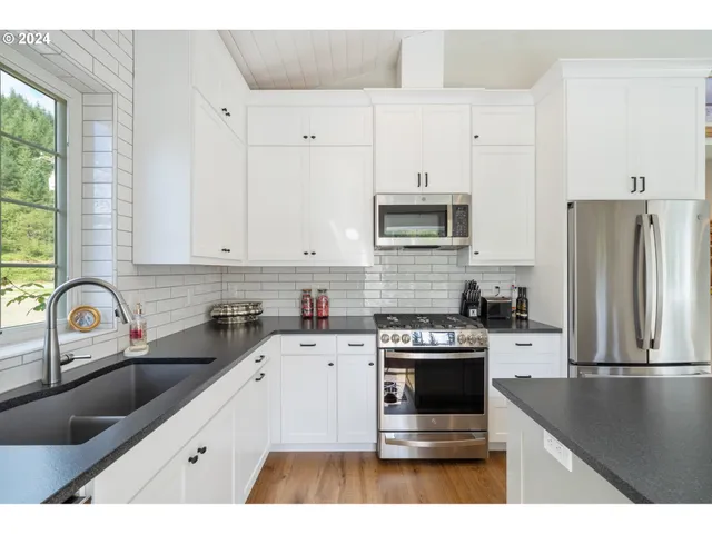 a kitchen with a sink stove top oven and refrigerator