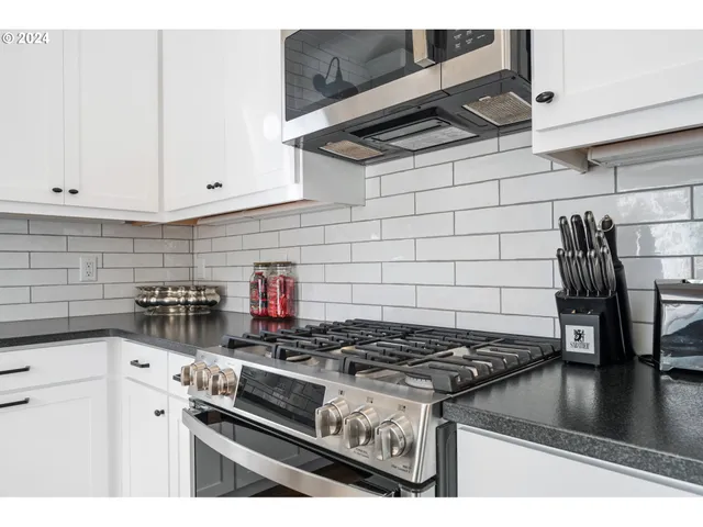 a kitchen with a stove and white cabinets