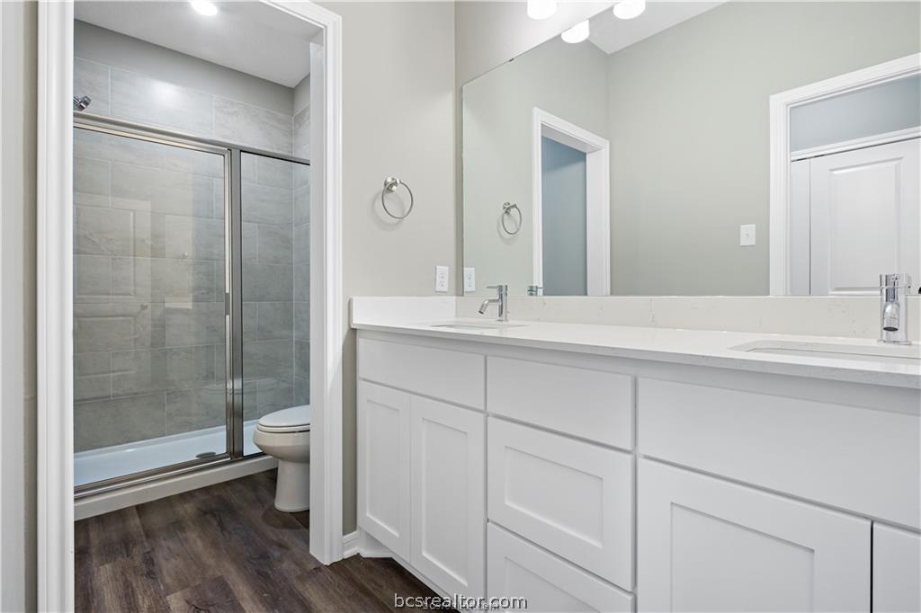 1245 Storm Row Lane Bryan, TX 77803 - Photo 13 of 23 a bathroom with a double vanity sink toilet and shower