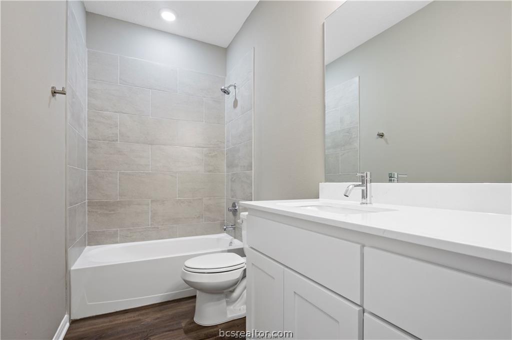 1245 Storm Row Lane Bryan, TX 77803 - Photo 14 of 23 a bathroom with a bathtub shower sink vanity mirror and toilet