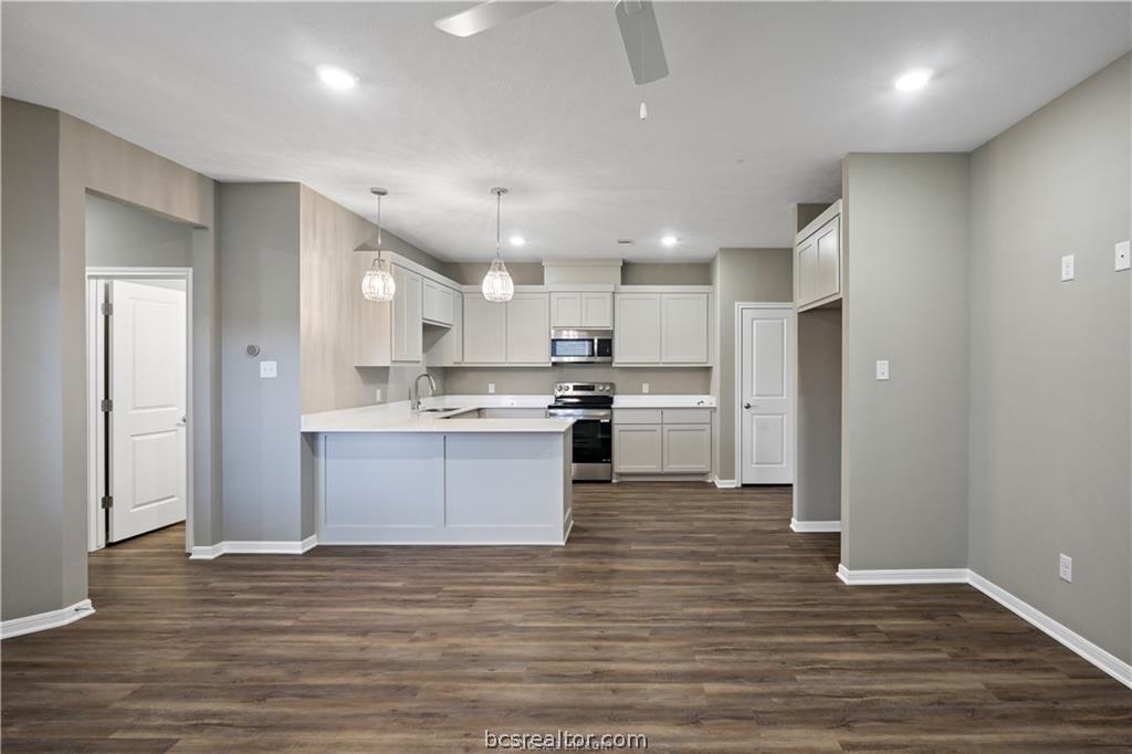 1245 Storm Row Lane Bryan, TX 77803 - Photo 6 of 23 a large kitchen with a center island wooden floor stainless steel appliances and cabinets