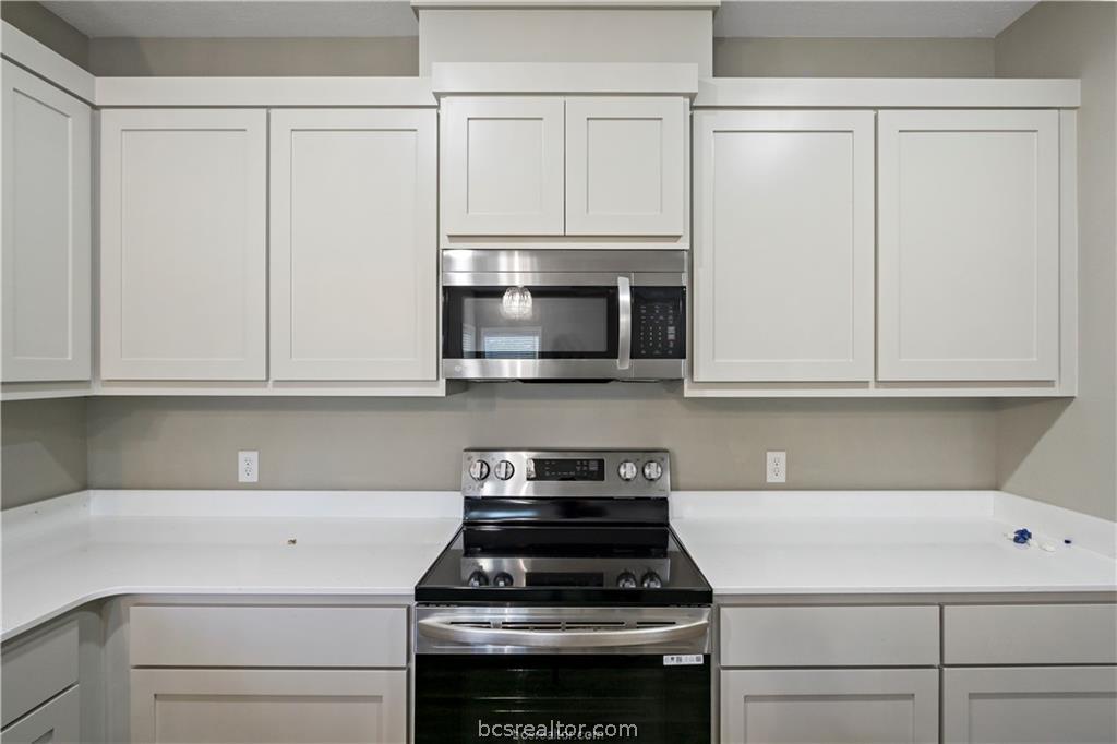 1245 Storm Row Lane Bryan, TX 77803 - Photo 8 of 23 a kitchen with granite countertop white cabinets and stainless steel appliances