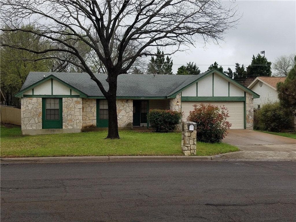 a front view of a house with a garden and trees