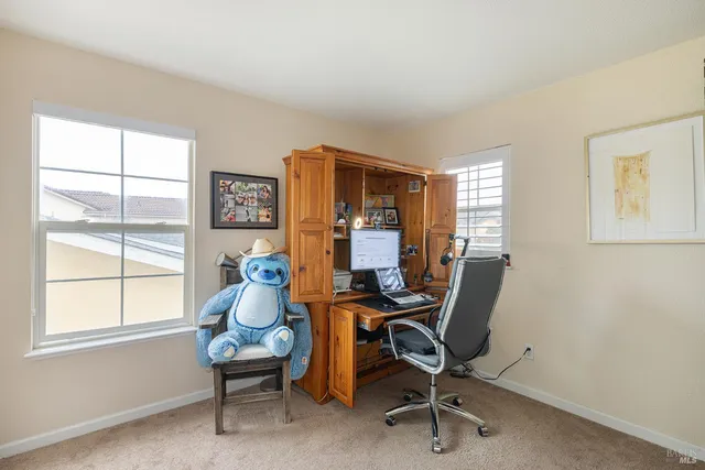 a view of a workspace with furniture and a window