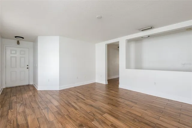a view of an empty room with wooden floor