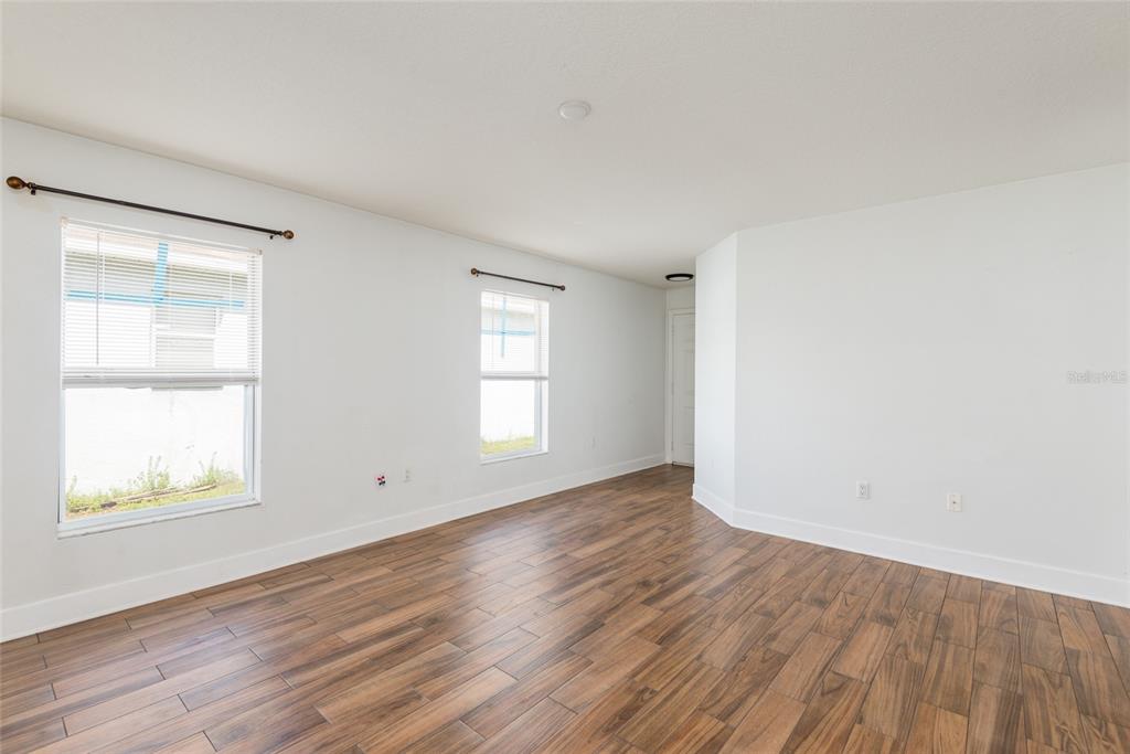 11813 Prickly Pear Way Seffner, FL 33584 - Photo 5 of 21 an empty room with wooden floor and windows