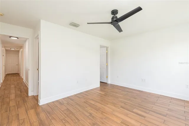a view of a room with wooden floor and a ceiling fan