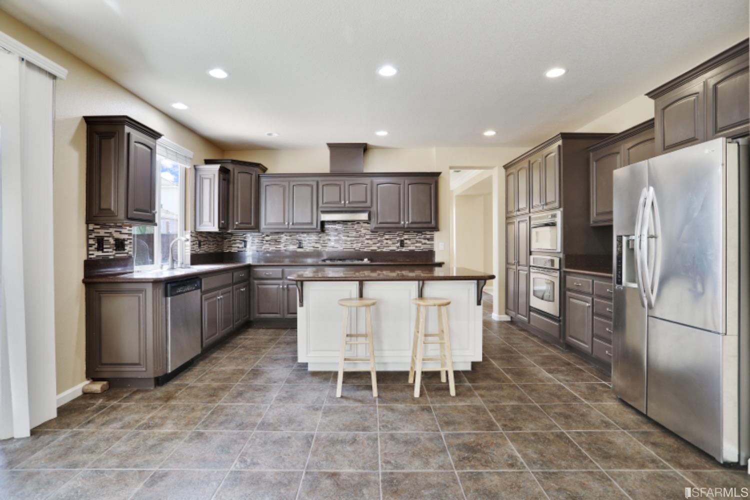 3444 Keystone Loop Discovery Bay, CA 94505 - Photo 8 of 40 a kitchen with a refrigerator a counter top space appliances and a center island