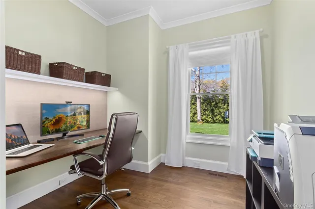 a view of a workspace with furniture and a window
