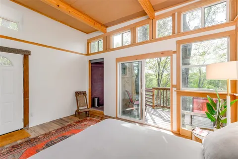 a bedroom with a bed and a large window with balcony view