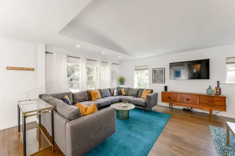 a living room with furniture wooden floor and a flat screen tv
