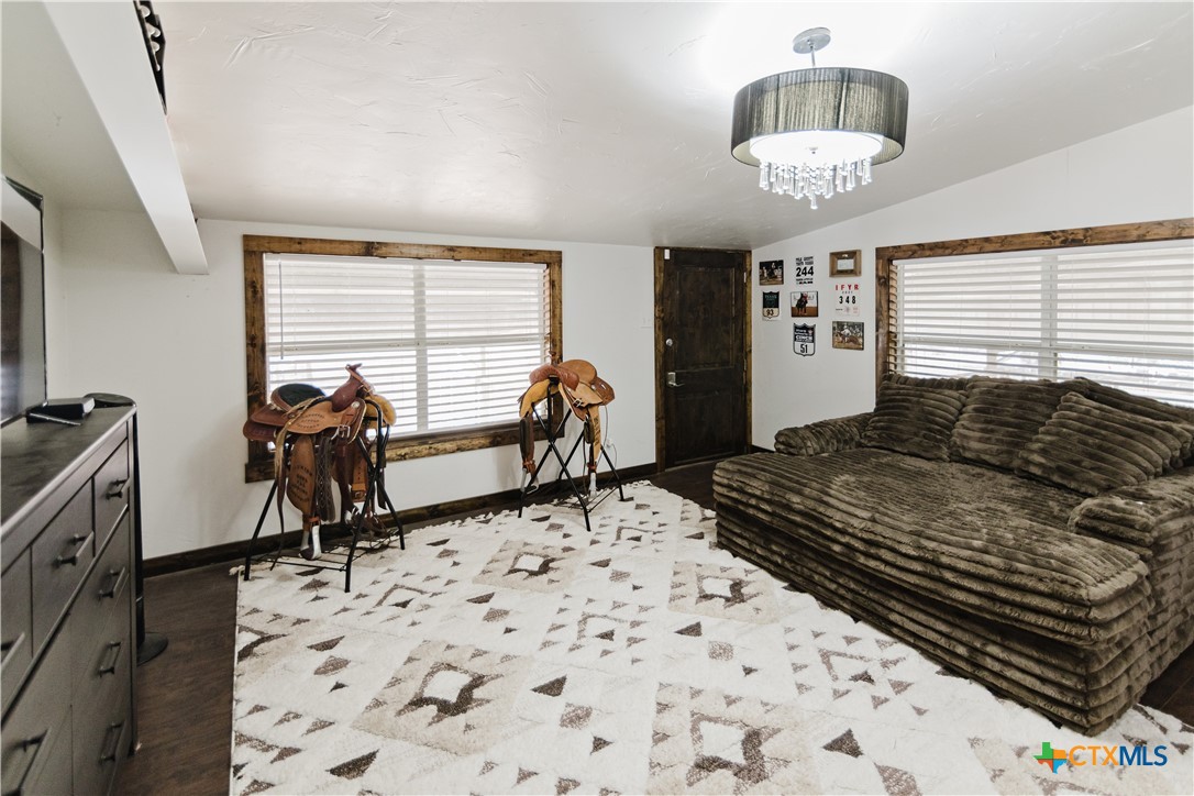 1440 Old Goliad Road Cuero, TX 77954 - Photo 19 of 41 a bedroom with a bed and a chandelier