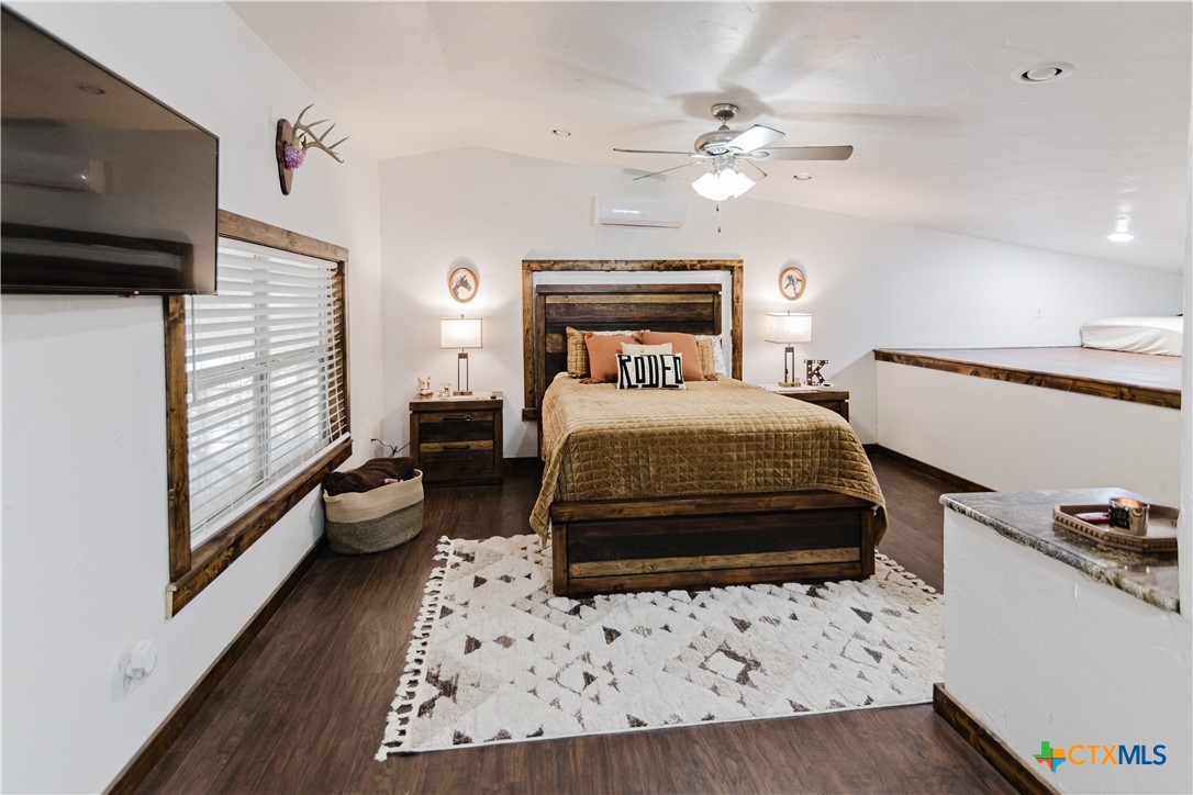 1440 Old Goliad Road Cuero, TX 77954 - Photo 20 of 41 a bedroom with a bed and a large window with wooden floor