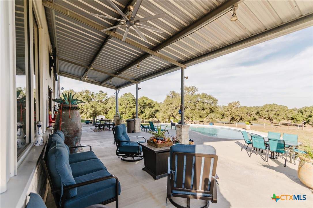 1440 Old Goliad Road Cuero, TX 77954 - Photo 22 of 41 a living room with patio furniture and a floor to ceiling window next to a yard