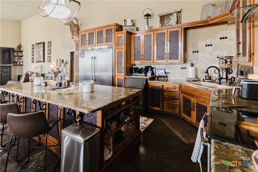 1440 Old Goliad Road Cuero, TX 77954 - Photo 8 of 41 a kitchen with stainless steel appliances a stove a sink dishwasher a dining table and chairs with wooden floor