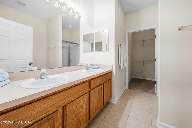 a spacious bathroom with a double vanity sink mirror and double