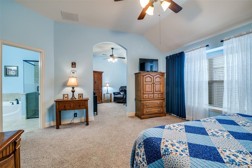 1036 Glenn Road Lavon, TX 75166 - Photo 16 of 30 a bedroom with a bed and a chandelier