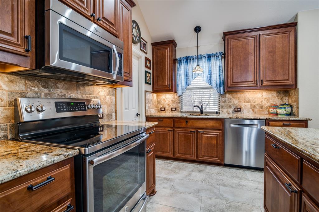 1036 Glenn Road Lavon, TX 75166 - Photo 6 of 30 a kitchen with stainless steel appliances granite countertop a stove microwave and cabinets