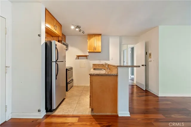 a kitchen with refrigerator a microwave and wooden floor