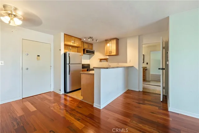 a view of a kitchen with wooden floor electronic appliances and window