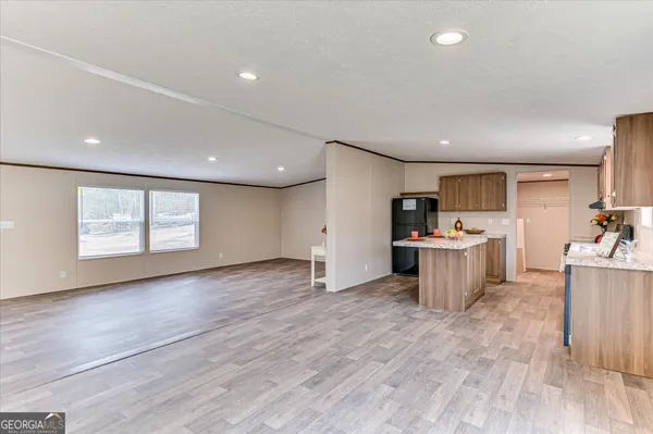 a view of a big room with wooden floor and windows