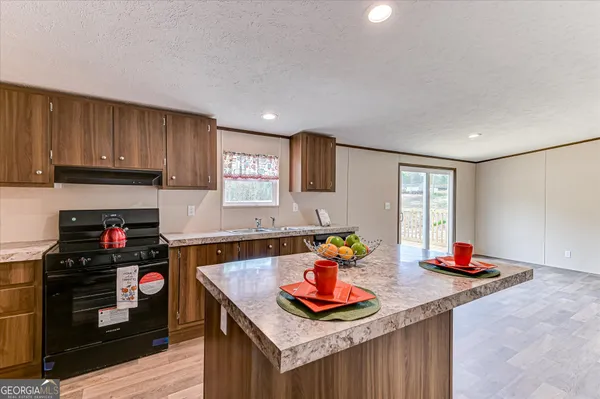 a kitchen with stainless steel appliances granite countertop a sink stove and cabinets