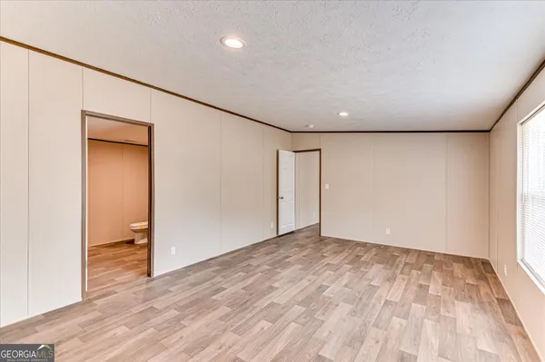 an empty room with wooden floor and closet
