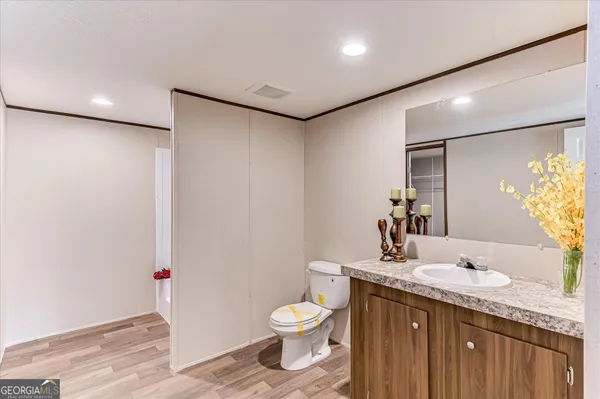 a bathroom with a granite countertop sink a toilet and a mirror