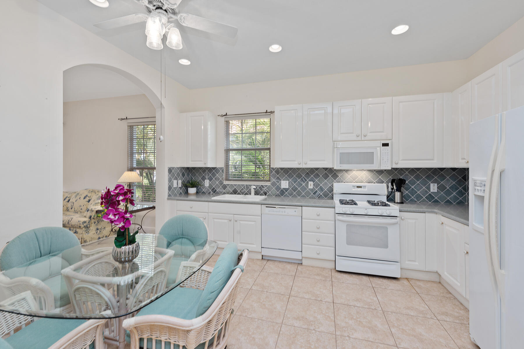 9082 Cascada Way, Unit 202 Naples, FL 34114 - Photo 5 of 37 a kitchen with granite countertop white cabinets stainless steel appliances and a dining table