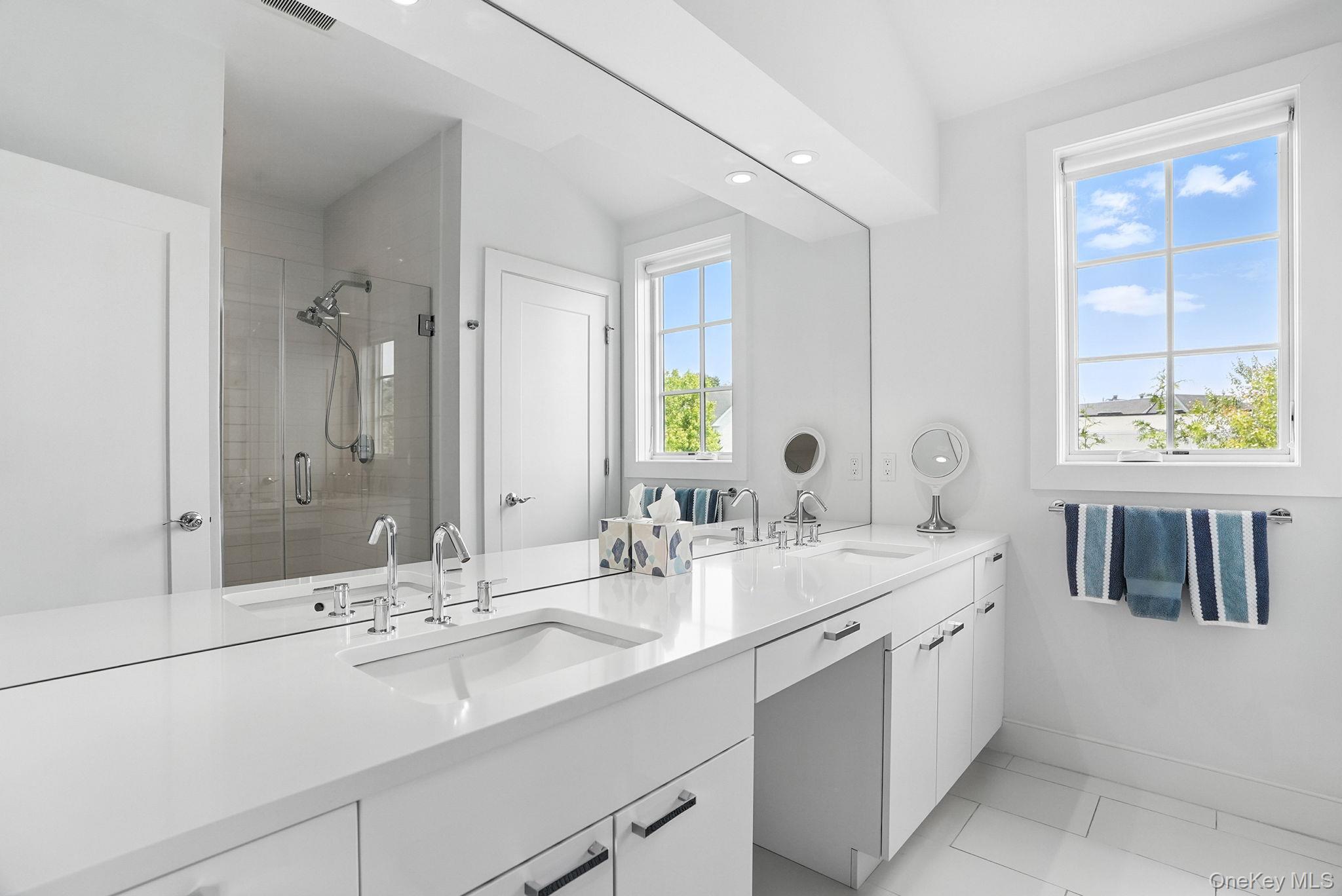 27 Lavender Lane Rye Brook, NY 10573 - Photo 17 of 33 a bathroom with a double vanity sink a mirror and next to a window