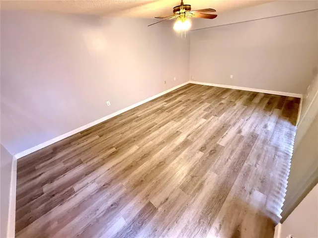 a view of a room with a fan and wooden floor
