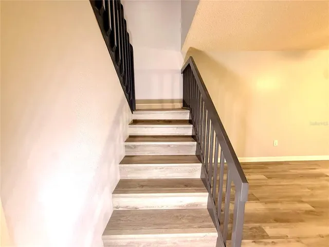 a view of staircase with railing and white walls