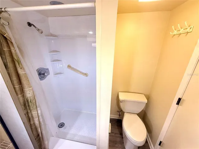 a white toilet sitting next to a shower