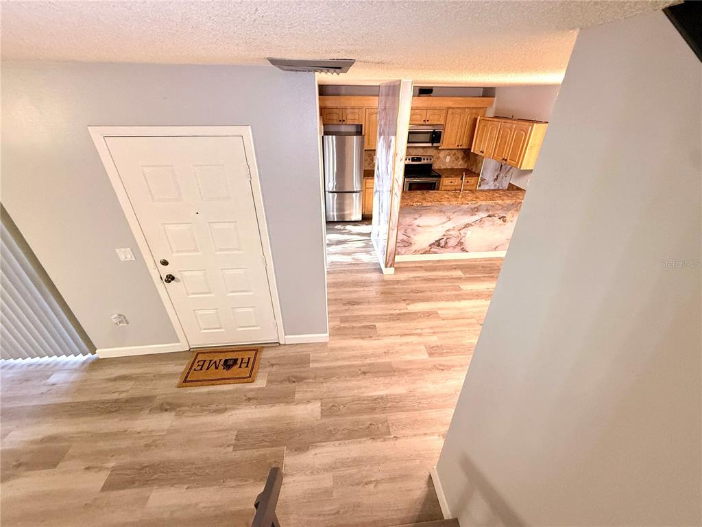 2727 14th Court Palm Harbor, FL 34684 - Photo 3 of 42 a view of a hallway with wooden floor and a living room