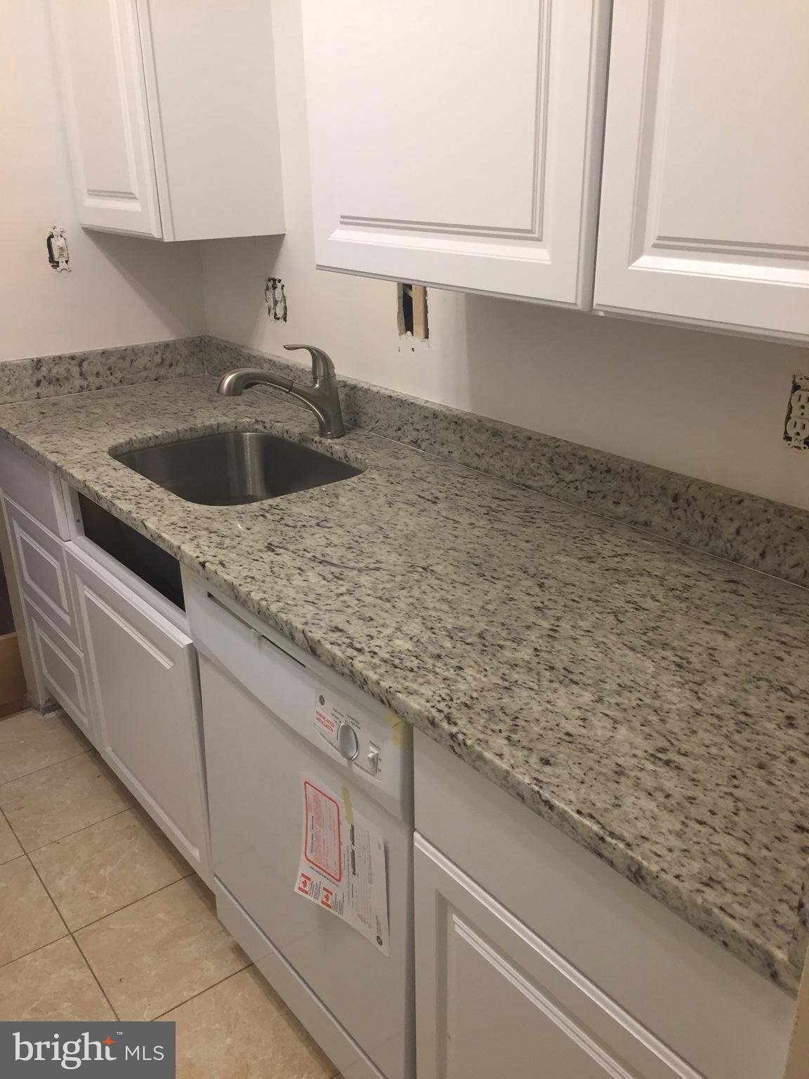 12700 Epping Terrace, Unit 8D Silver Spring, MD 20906 - Photo 4 of 6 a kitchen with granite countertop white cabinets and a sink
