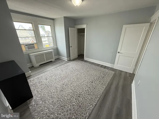 an empty room with wooden floor and toilet