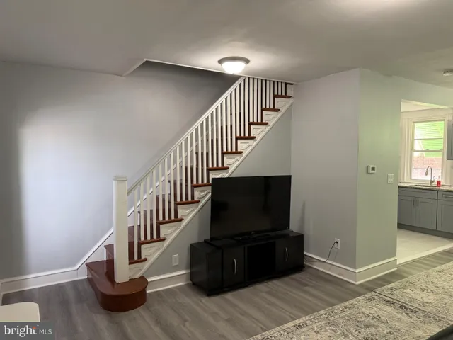 a living room with stairs and a flat screen tv