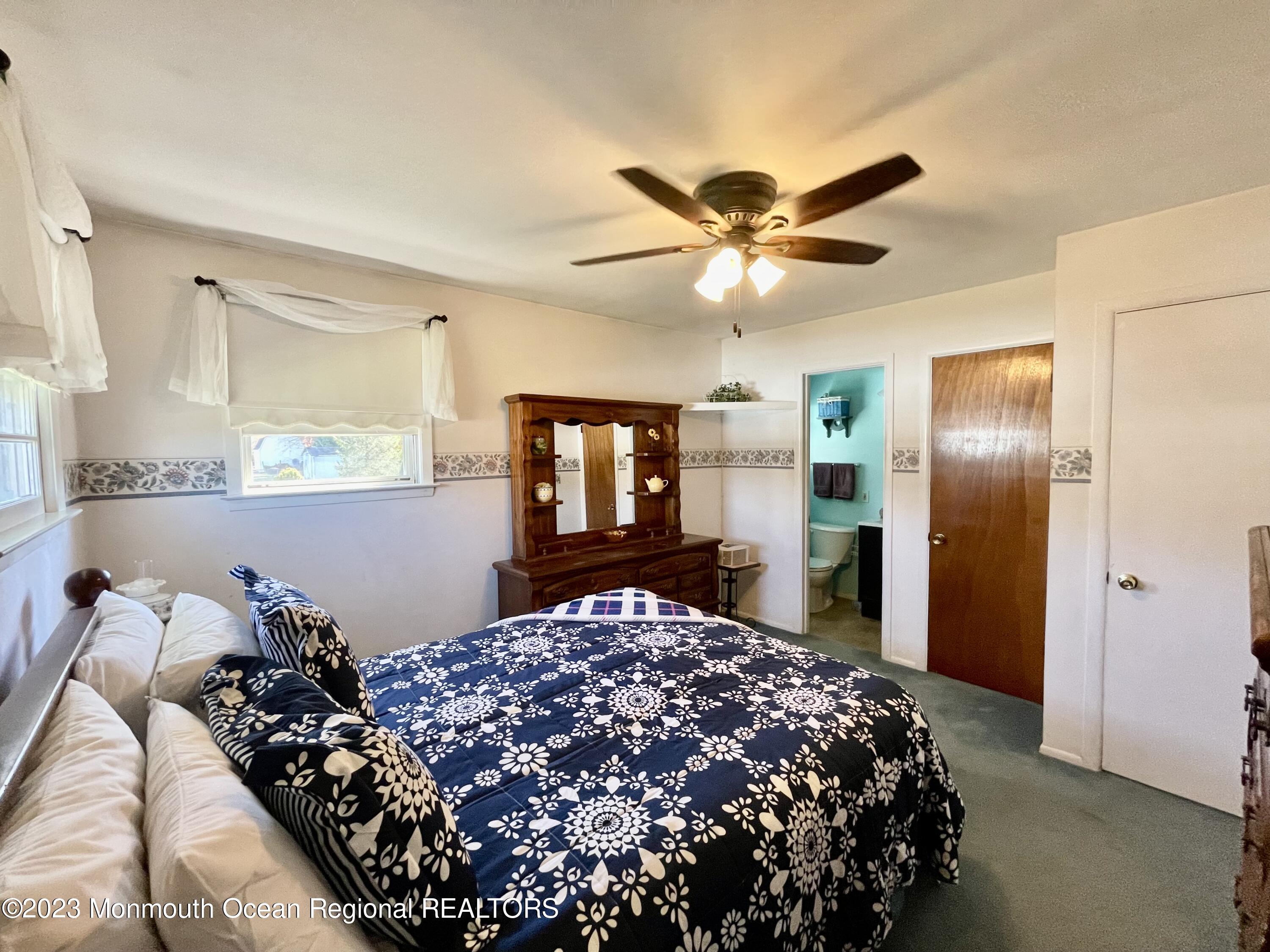 22 Saranac Road Hamilton, NJ 08619 - Photo 4 of 33 a bedroom with a large bed and a chandelier