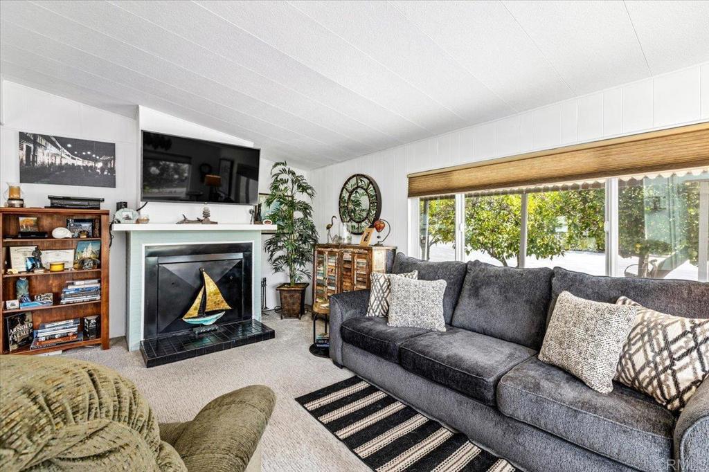 18218 Paradise Mountain Road, Unit 116 Valley Center, CA 92082 - Photo 2 of 35 a living room with furniture a flat screen tv and a fireplace