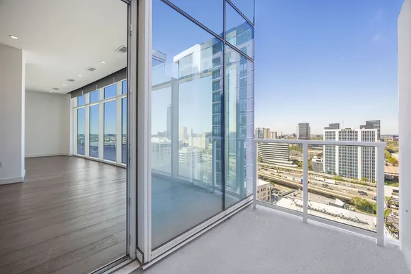 a view of a room with floor to ceiling windows and wooden floor