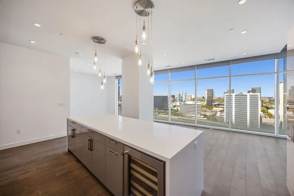 a kitchen with stainless steel appliances kitchen island granite countertop a sink and a refrigerator