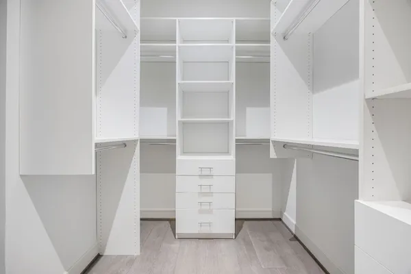 a view of walk in closet with empty racks