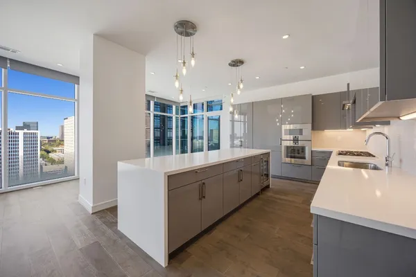 a large white kitchen with wooden floor