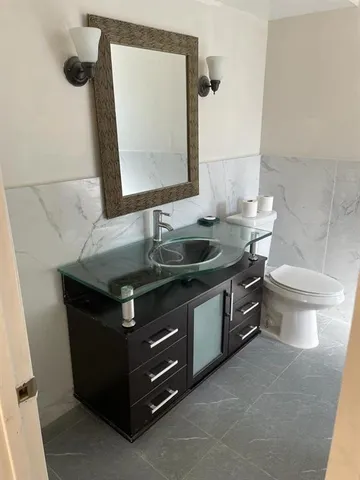 a bathroom with a granite countertop sink and a mirror