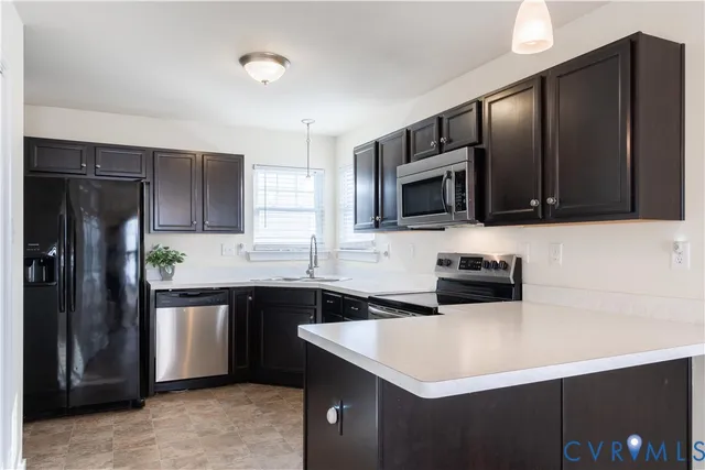 a kitchen with stainless steel appliances granite countertop a refrigerator a stove top oven a sink and dishwasher