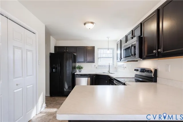 a kitchen with stainless steel appliances a stove sink microwave and refrigerator
